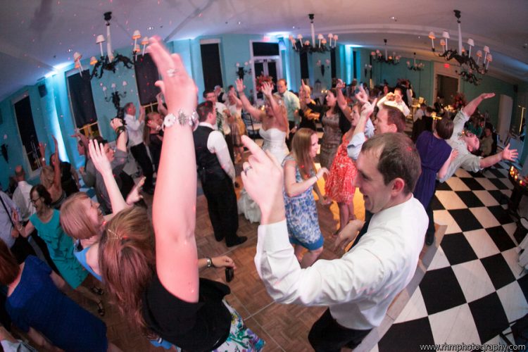 Wedding guests dancing together on packed dance floor during lively wedding reception celebration