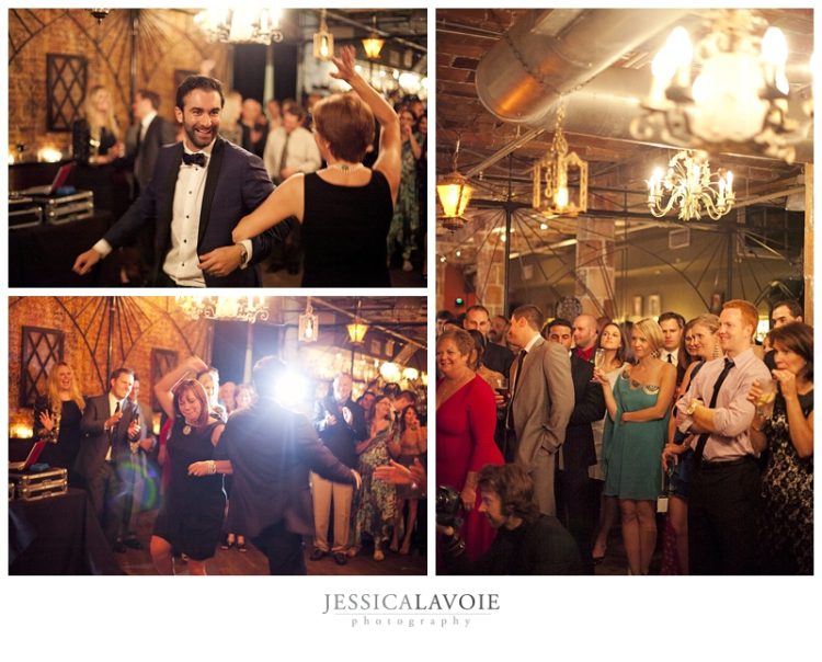 Wedding guests dancing and watching celebration inside rustic industrial reception venue