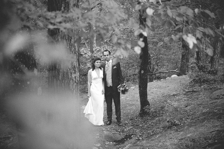 Bride and groom standing together in wooded outdoor setting