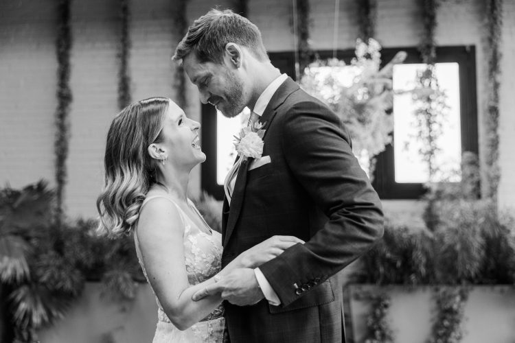 Bride and groom smiling together during indoor wedding portrait session