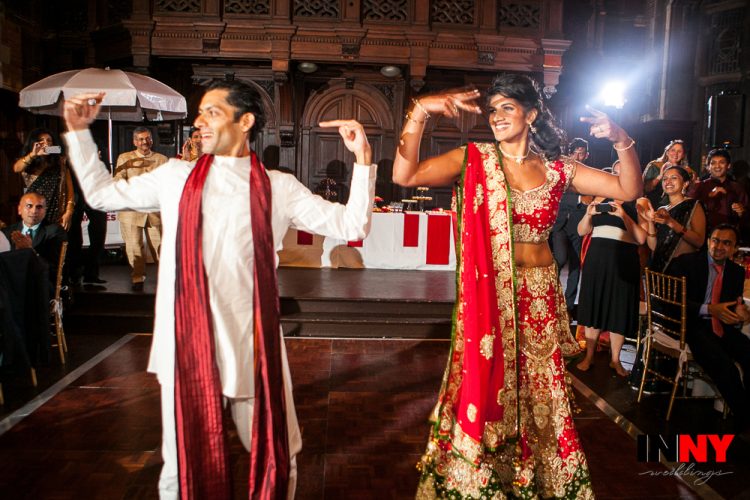 Couple performing lively traditional dance at wedding reception while guests watch and cheer at Highline Hotel