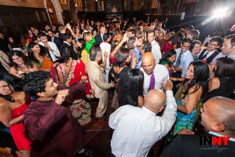 Crowded wedding dance floor filled with guests celebrating and dancing energetically