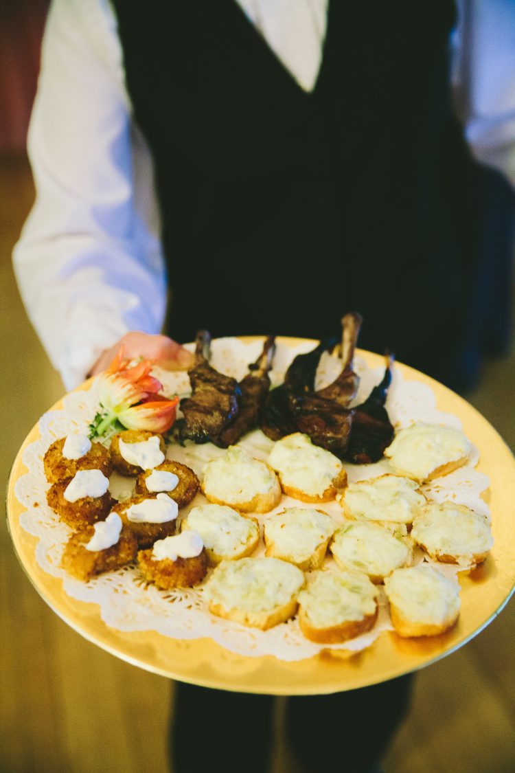 Server holding tray of appetizers during indoor reception
