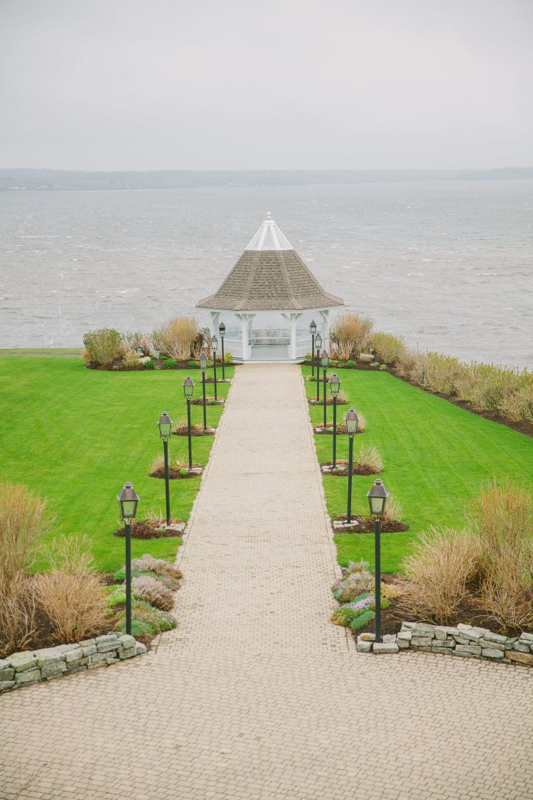 Lakeside gazebo at end of path with lined lanterns and manicured lawn at French’s Point