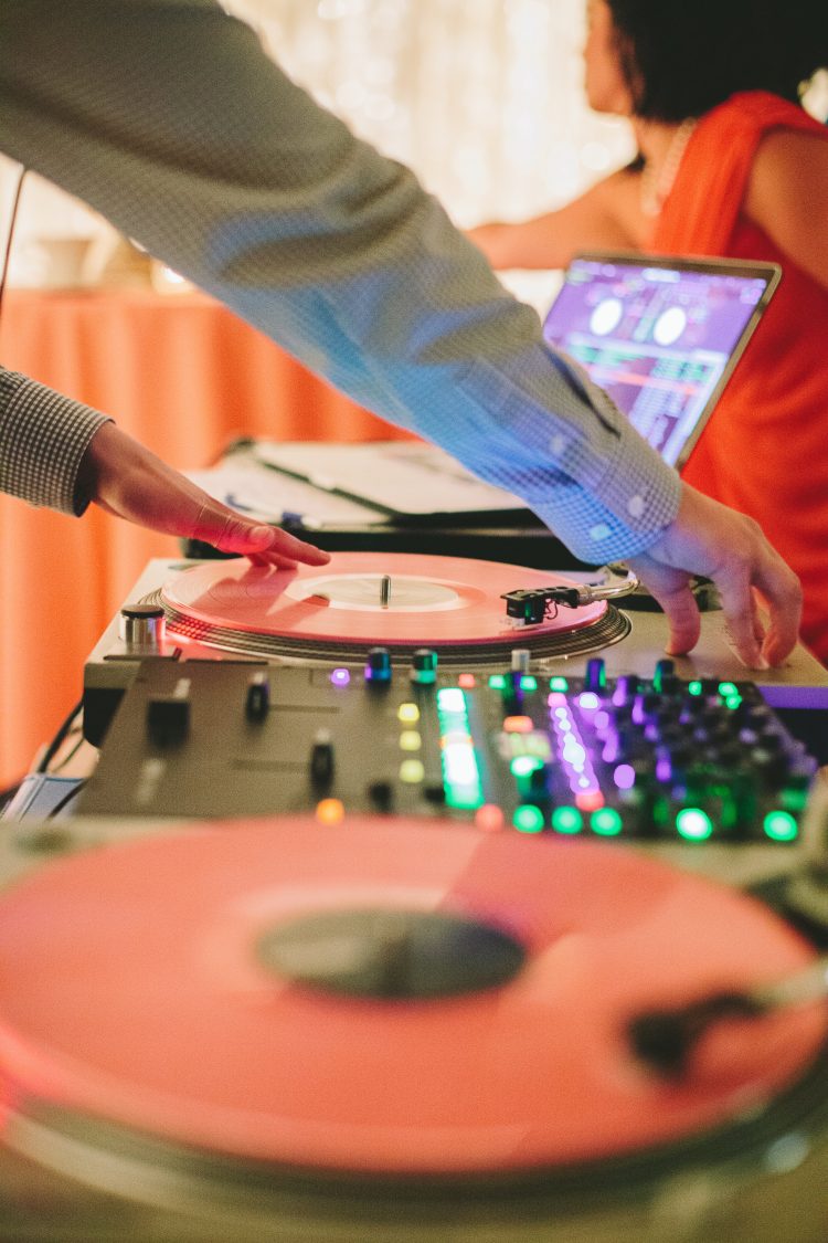 DJ adjusting turntable and mixer during wedding reception set