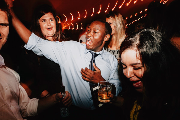 Wedding guests dancing and singing during energetic reception celebration