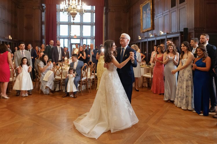 Bride sharing father-daughter dance in elegant ballroom.