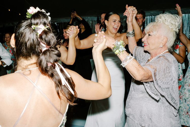 Bride dancing joyfully with family and guests.