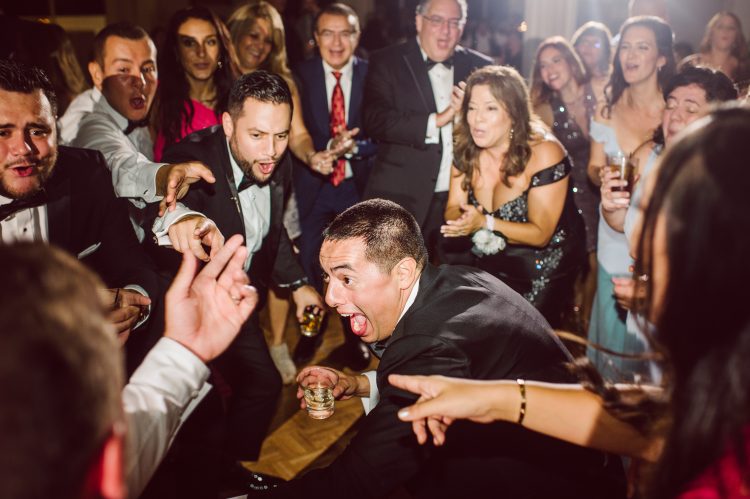 Guests cheering around a friend during a dance floor moment.