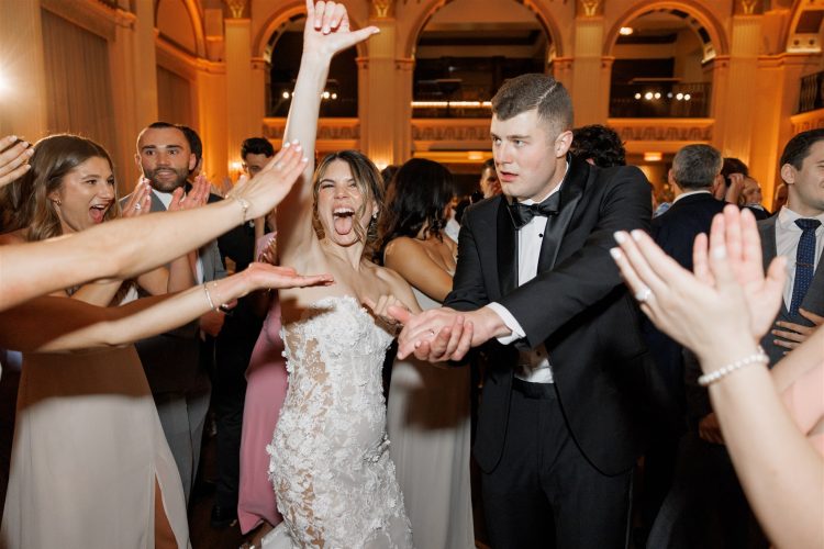 Bride celebrating with guests on the dance floor.