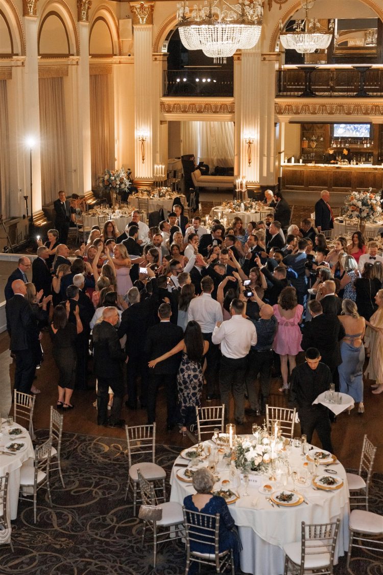 Crowded wedding dance floor in a grand ballroom.