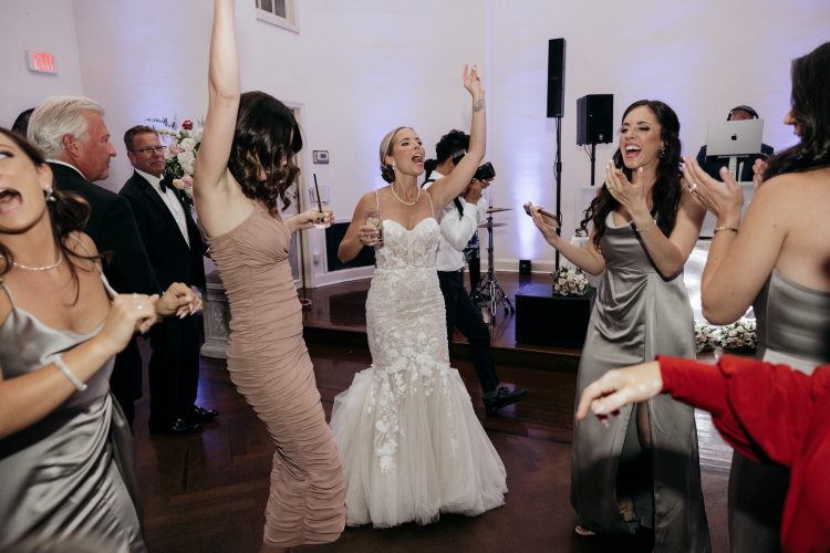 Bride dancing with friends on the reception dance floor.