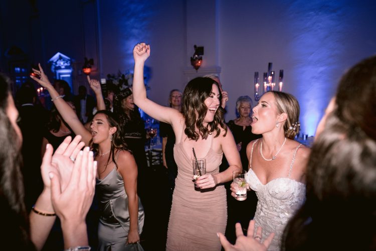 Bride celebrating with friends on the dance floor.