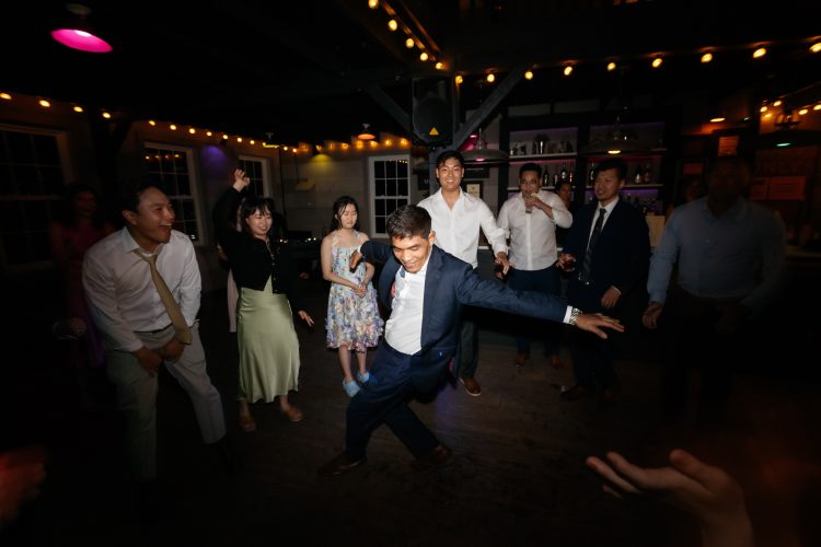 Guest showing off dance moves while friends cheer on the dance floor.