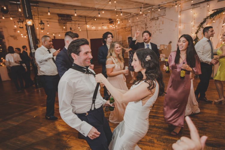 Bride playfully dancing with groom on the dance floor.