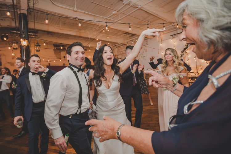 Bride dancing and pointing during reception celebration.
