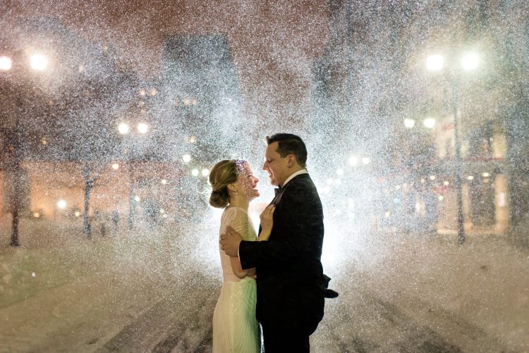 Couple embracing in the snow at night.