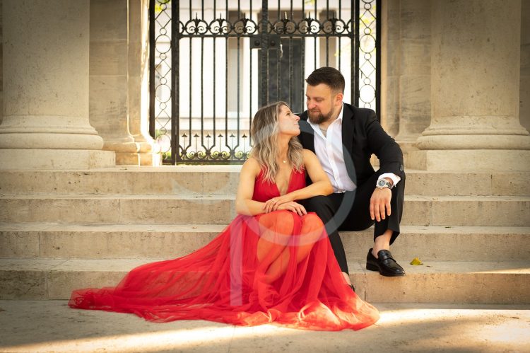 Couple sitting on stone steps looking at each other.