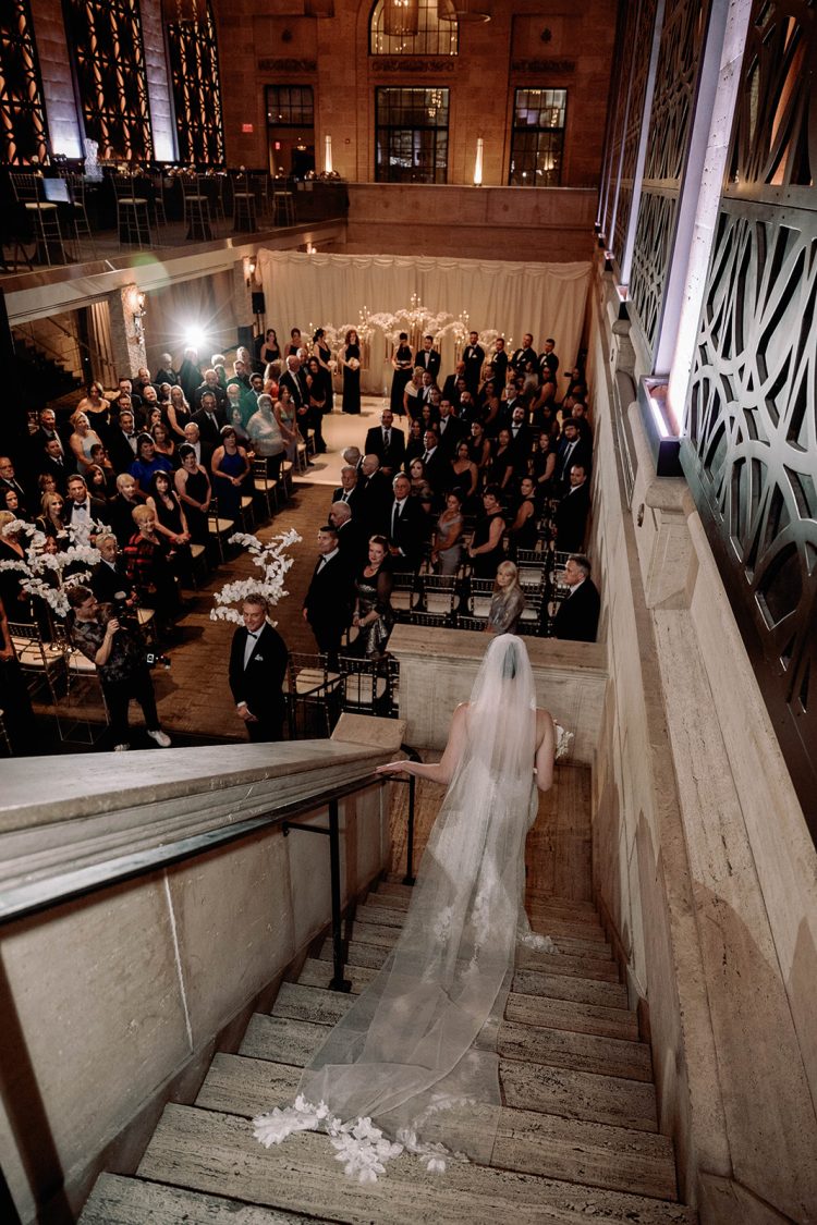 Bride walking down the stairs toward the wedding ceremony.