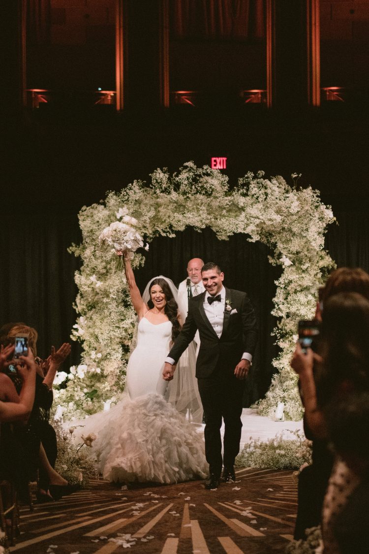 Bride and groom walking down the aisle after the ceremony at Gotham Hall.
