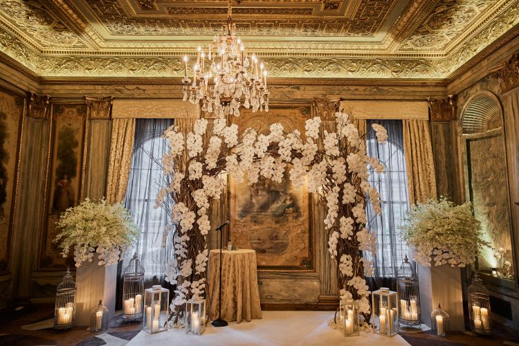 Wedding ceremony setup with floral arch in an elegant hall at Lotte New York Palace