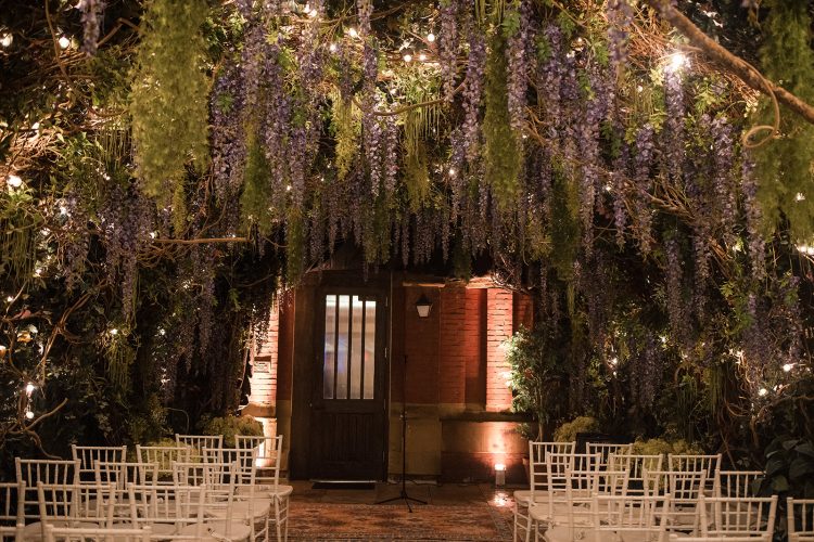 Wedding ceremony setup under hanging flowers and lights at The Beekman Hotel.