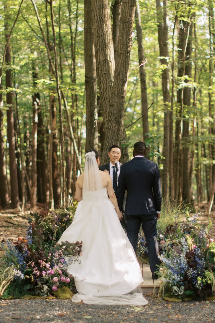 Couple standing at altar during outdoor forest wedding ceremony at Gather Greene