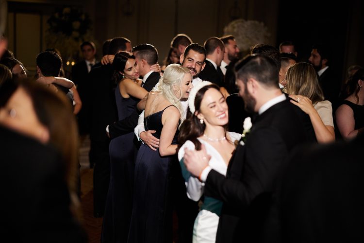 Wedding guests slow dancing together on crowded reception dance floor at Lotte New York Palace