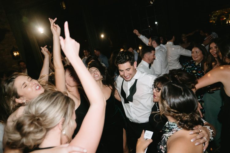 Wedding guests dancing and celebrating on crowded dance floor at Bowery Hotel