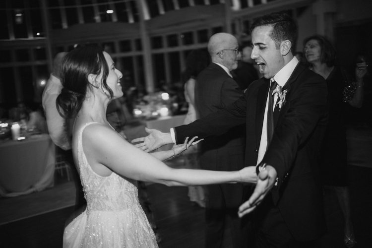 Bride and groom excitedly dancing together at wedding reception at Brooklyn Botanical Garden