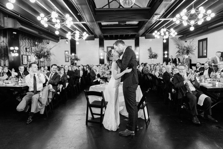 Bride and groom sharing first kiss at wedding reception at 501 Union