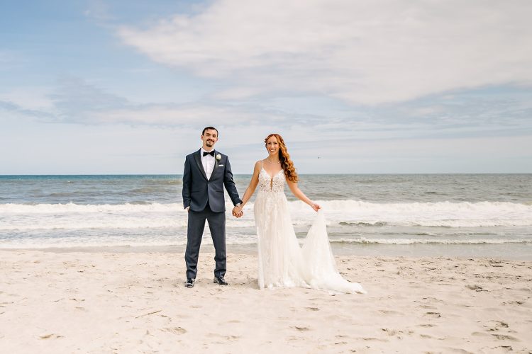 Bride and groom holding hands on the beach at Oceanbleu at Westhampton