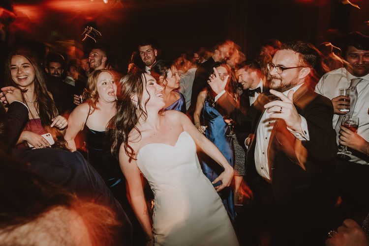 Bride dancing with guests on packed wedding reception dance floor