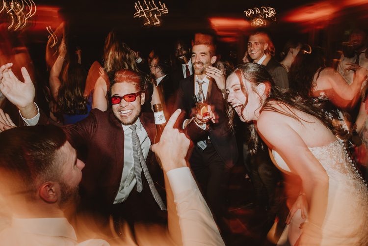 Bride dancing with wedding guests on packed reception dance floor