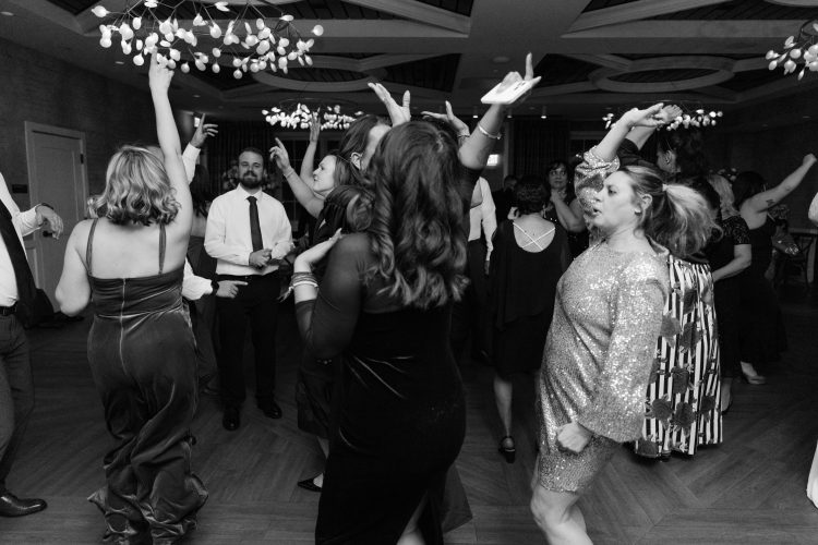 Guests dancing energetically at wedding reception dance floor