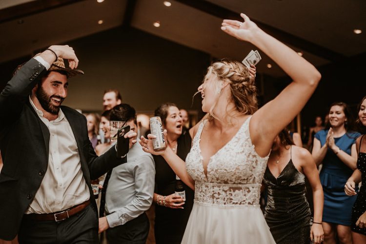 Bride dancing with guests at lively wedding reception.