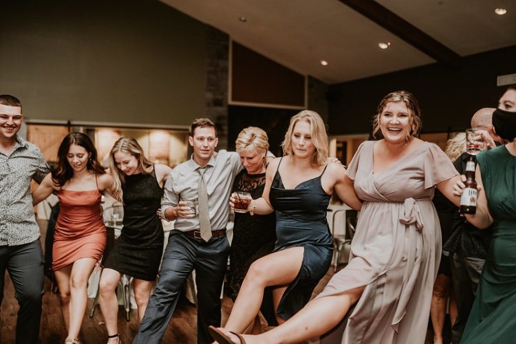 Guests performing a group dance at wedding reception.