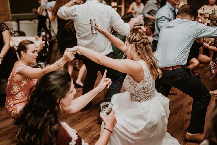 Bride dancing with wedding guest during lively reception celebration