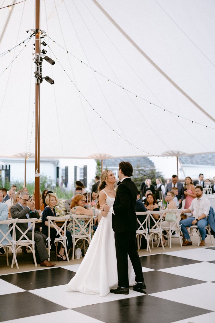 Romantic first dance under the tent with everyone watching.