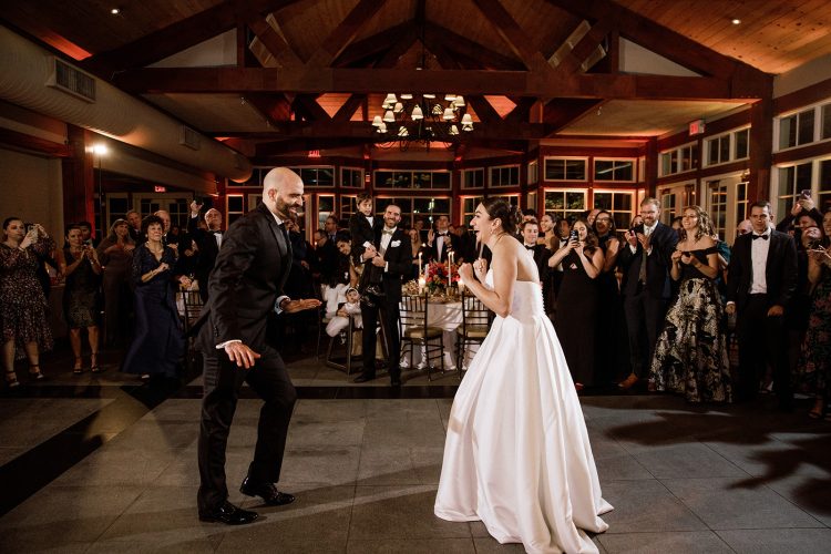 Fun wedding dance off with the couple surrounded by cheering guests.