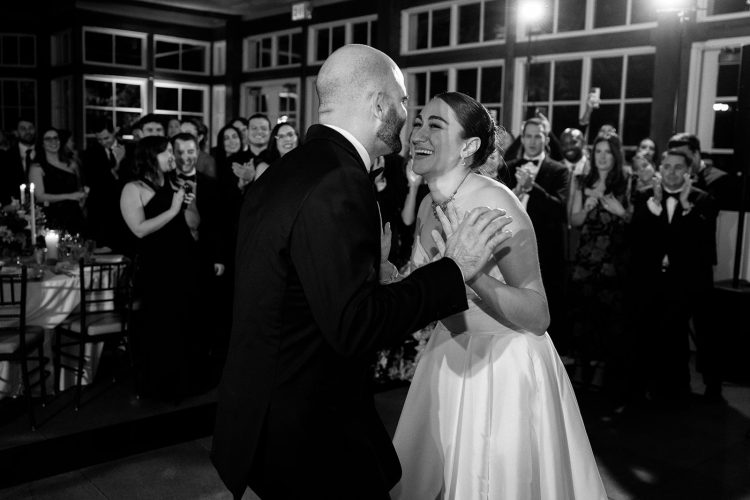 Joyful wedding dance moment with the couple laughing together.