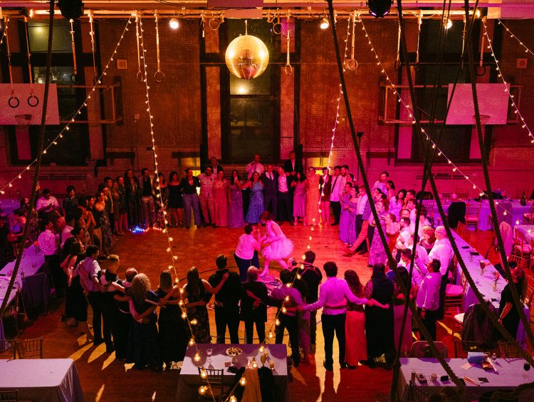 Big joyful wedding circle dance with everyone joining in under the lights.