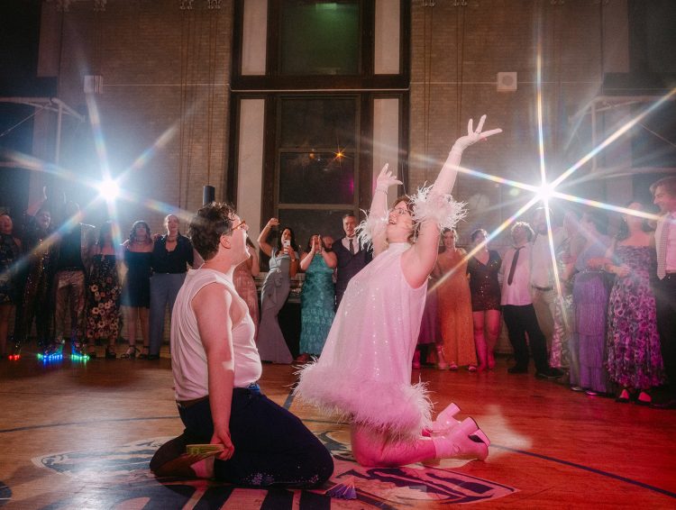 Dramatic wedding dance floor moment with a fun performance stealing the spotlight.