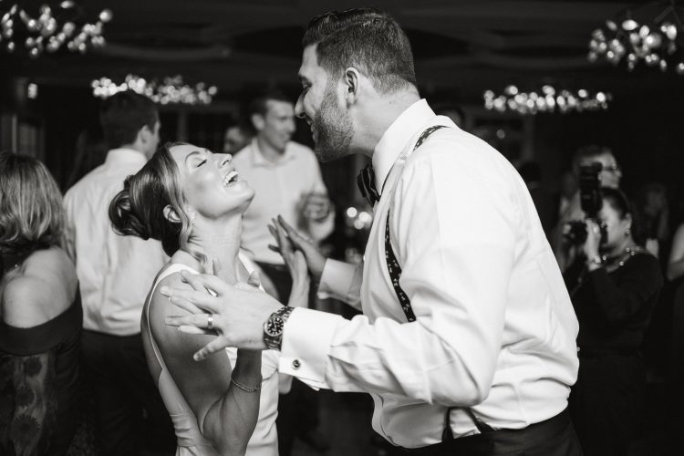 Bride and groom laughing together on the wedding reception dance floor