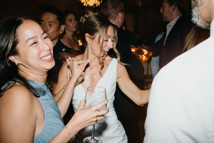 Wedding guests dancing and smiling together.
