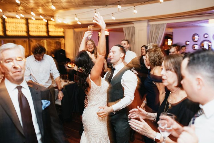 Couple dancing surrounded by guests at the reception.