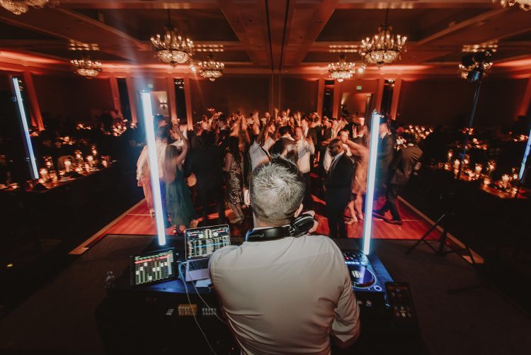 DJ performing for a packed wedding reception dance floor