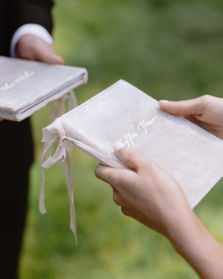 Bride and groom holding personalized wedding vow books