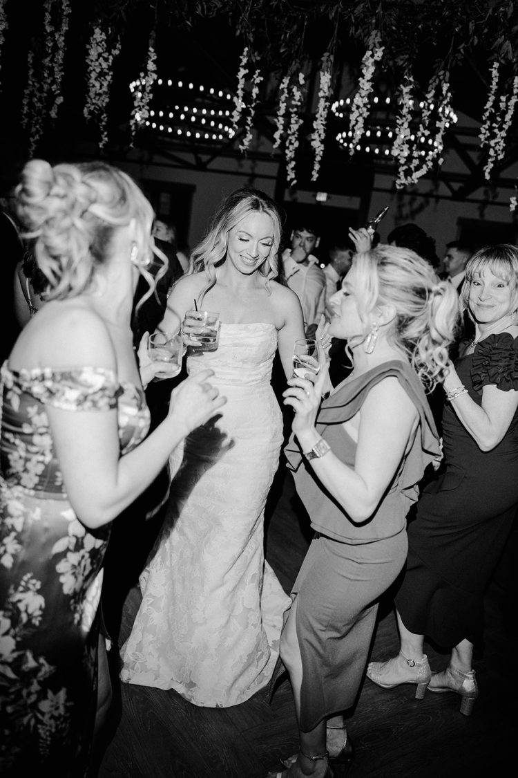 Bride dancing with wedding guests during a black-and-white reception celebration at Renault Winery