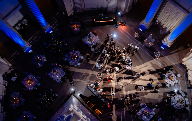 Overhead view of wedding guests dancing on reception dance floor.